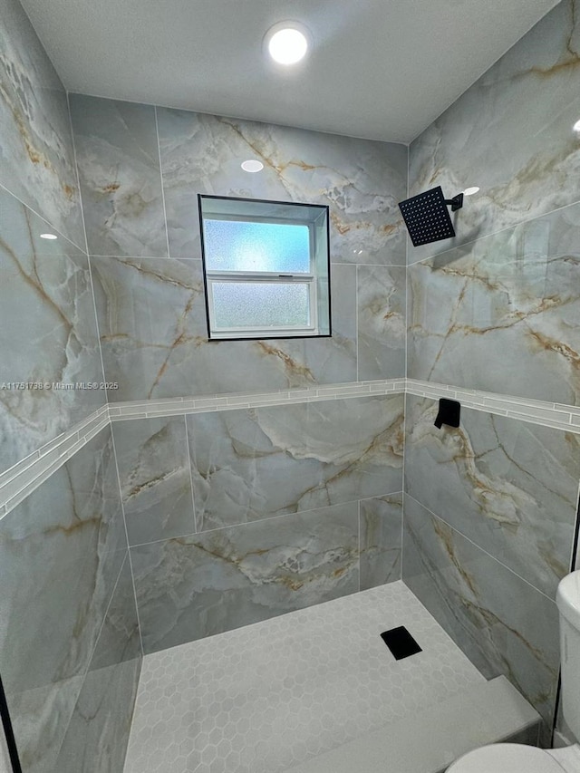 bathroom featuring toilet and tiled shower
