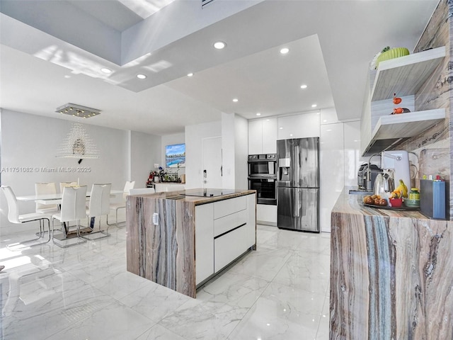 kitchen with stainless steel appliances, modern cabinets, a center island, and white cabinets