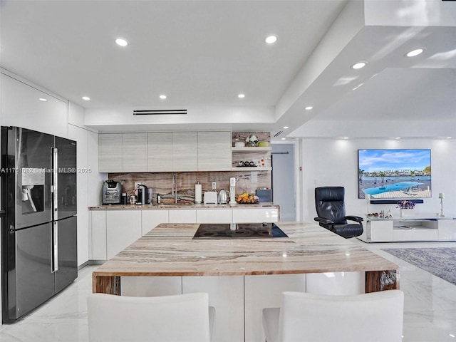 kitchen featuring open shelves, a kitchen breakfast bar, white cabinets, black appliances, and modern cabinets