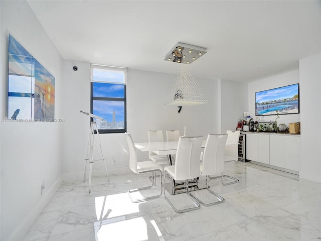 dining area with marble finish floor, wine cooler, and baseboards