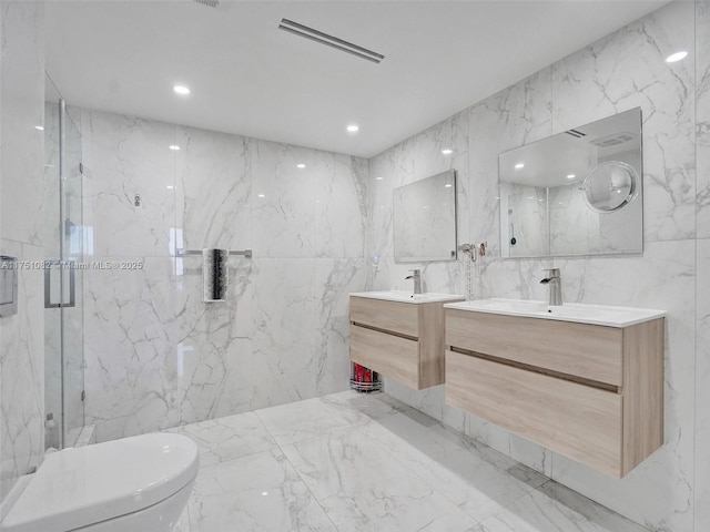 bathroom with marble finish floor, vanity, a marble finish shower, and stone wall