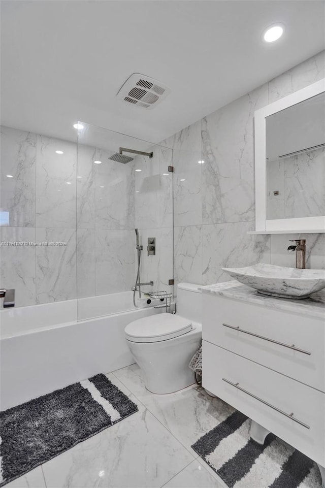 bathroom featuring marble finish floor, shower / bathtub combination, visible vents, toilet, and vanity