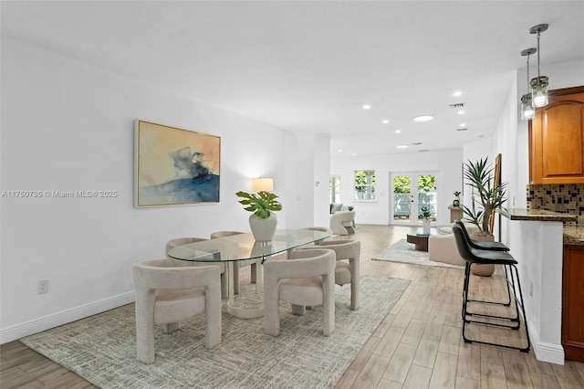 dining room featuring baseboards, french doors, recessed lighting, and light wood-style floors
