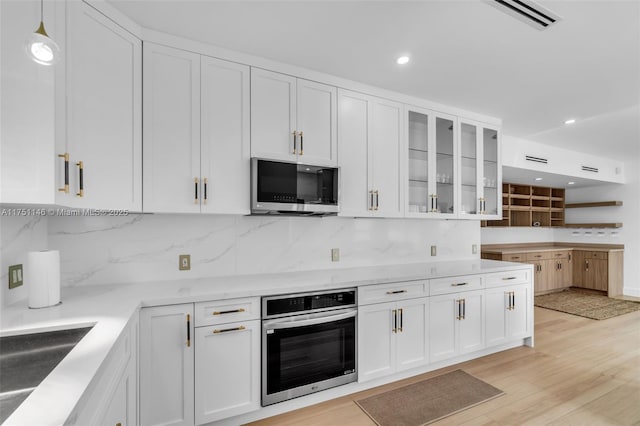 2043 SW 7th St, Miami, FL 33135 - kitchen featuring glass insert cabinets, white cabinetry, backsplash, and stainless steel appliances