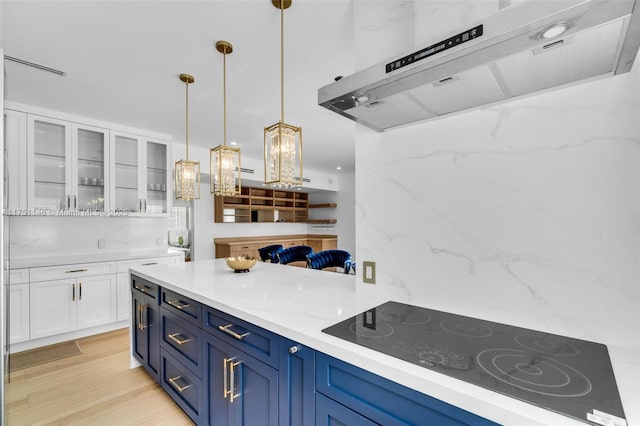 2043 SW 7th St, Miami, FL 33135 - bar with under cabinet range hood, black electric cooktop, pendant lighting, and light wood-style floors