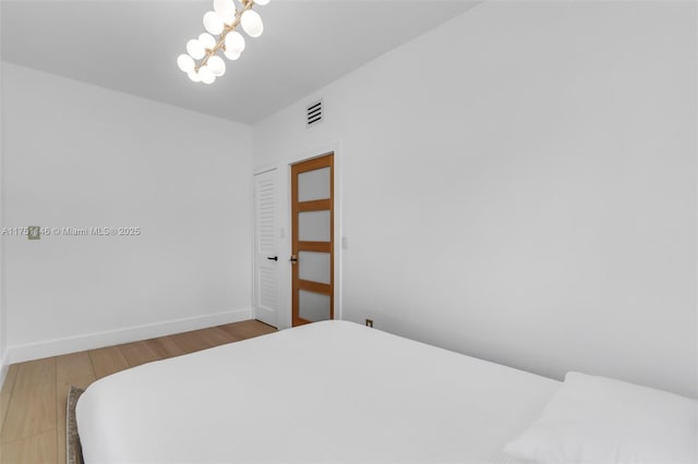 2043 SW 7th St, Miami, FL 33135 - bedroom featuring visible vents, baseboards, wood finished floors, and an inviting chandelier