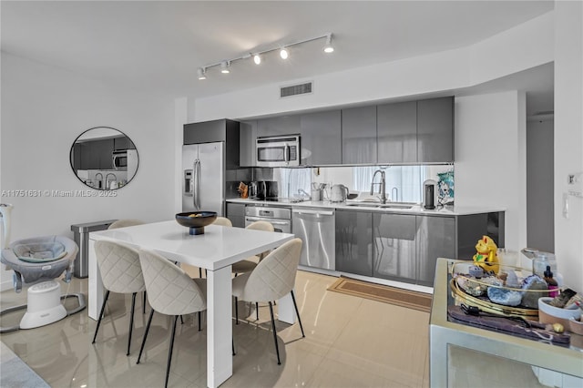 kitchen with a sink, visible vents, light countertops, appliances with stainless steel finishes, and modern cabinets