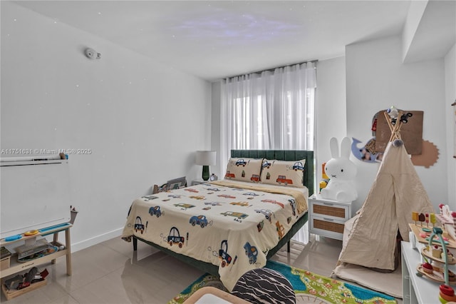 bedroom with light tile patterned flooring and baseboards