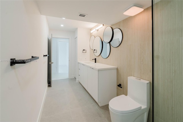 bathroom featuring visible vents, toilet, vanity, baseboards, and tile patterned floors