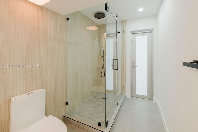 full bath with baseboards, a shower stall, toilet, and tile patterned floors