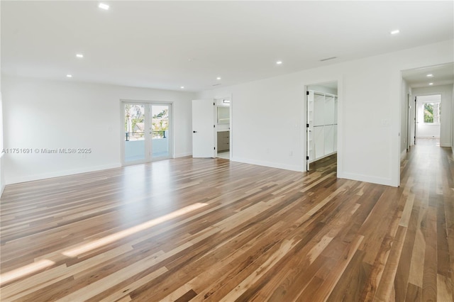 spare room with recessed lighting, french doors, plenty of natural light, and wood finished floors