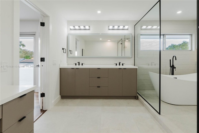 full bath with double vanity, a soaking tub, and a sink