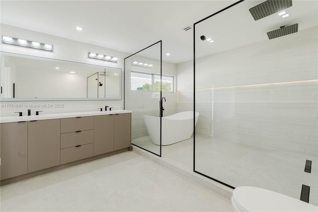 bathroom with a walk in shower, double vanity, a freestanding tub, and tile walls