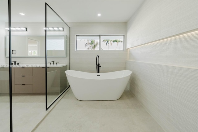 full bathroom featuring a soaking tub and vanity