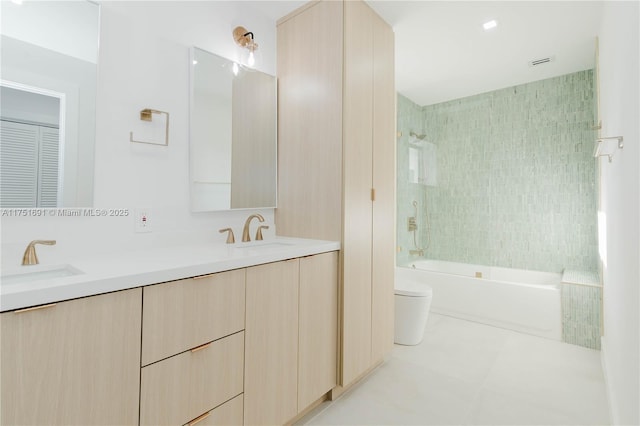 bathroom with double vanity, a closet, a sink, and toilet