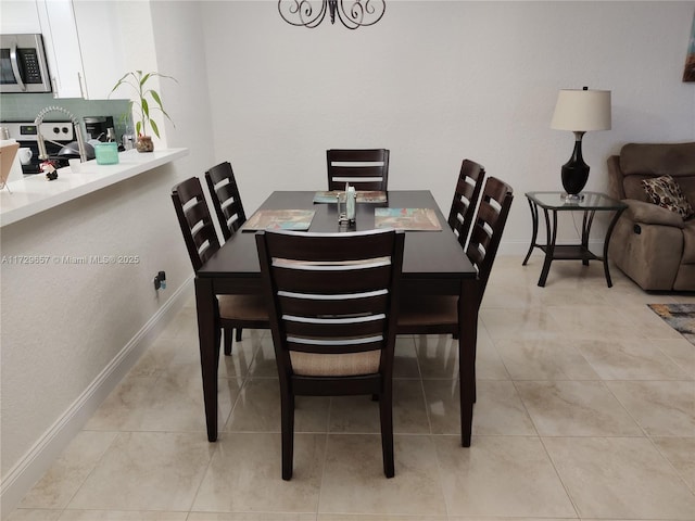 dining room featuring light tile patterned floors and baseboards