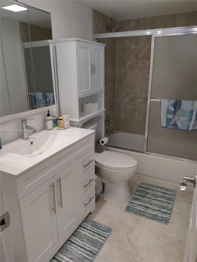 bathroom featuring enclosed tub / shower combo, vanity, and toilet