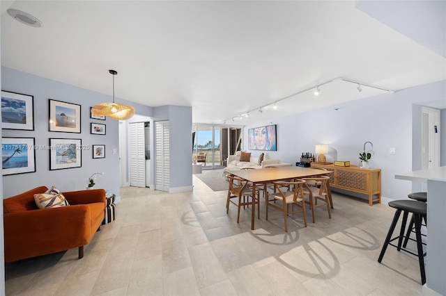 dining area featuring baseboards and track lighting