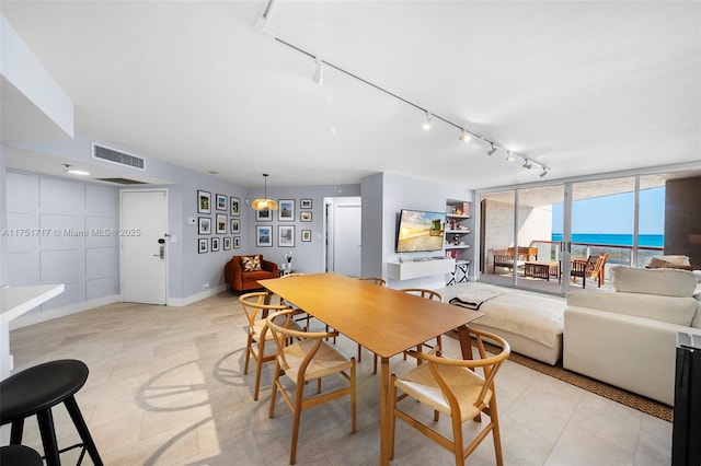 dining area with light tile patterned floors, baseboards, visible vents, and track lighting