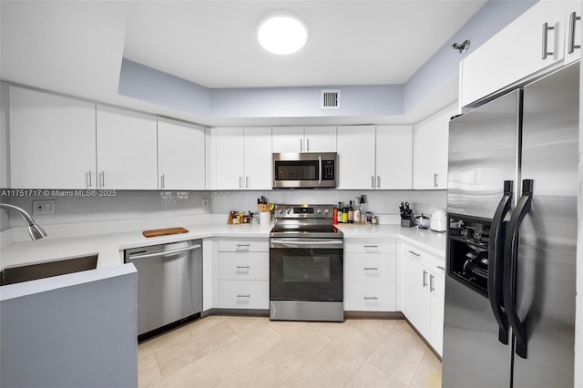 kitchen featuring white cabinets, stainless steel appliances, and light countertops