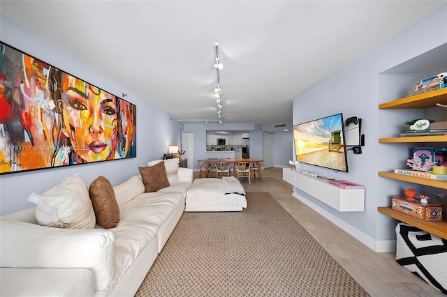 living area with built in shelves and track lighting