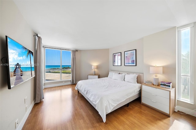 bedroom with access to outside, baseboards, and light wood finished floors