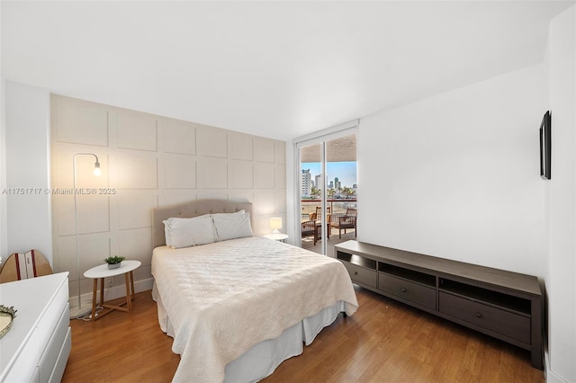 bedroom with light wood-type flooring and access to outside