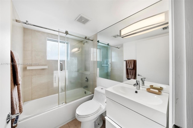 full bath featuring shower / bath combination with glass door, visible vents, toilet, vanity, and tile patterned floors