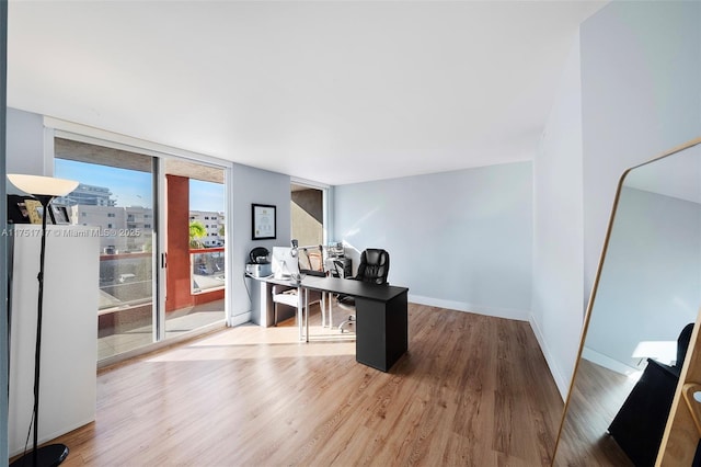 office area with baseboards and wood finished floors