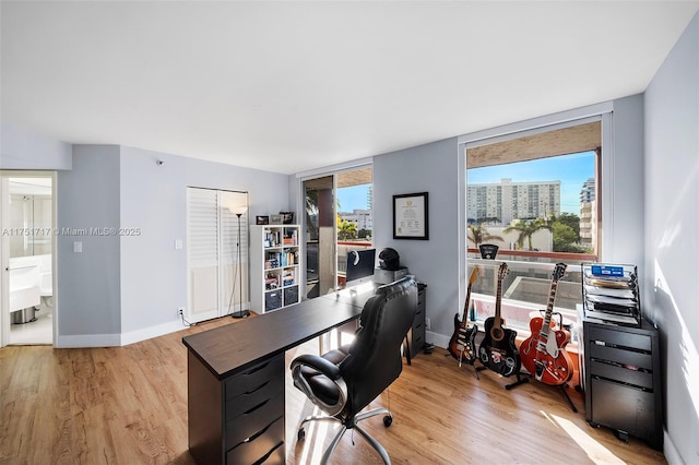 home office with baseboards and wood finished floors