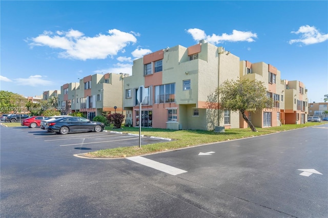 view of property featuring uncovered parking and a residential view