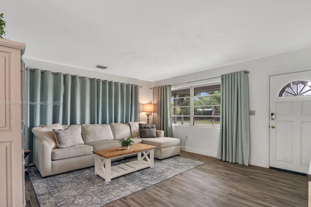 living room with visible vents, baseboards, and wood finished floors