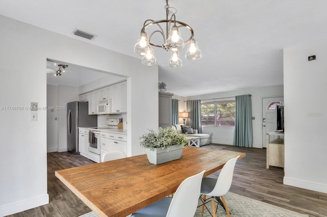 dining space with dark wood-type flooring, visible vents, and baseboards