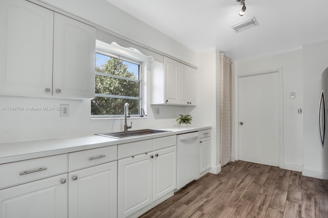 kitchen featuring visible vents, white dishwasher, light countertops, white cabinetry, and a sink