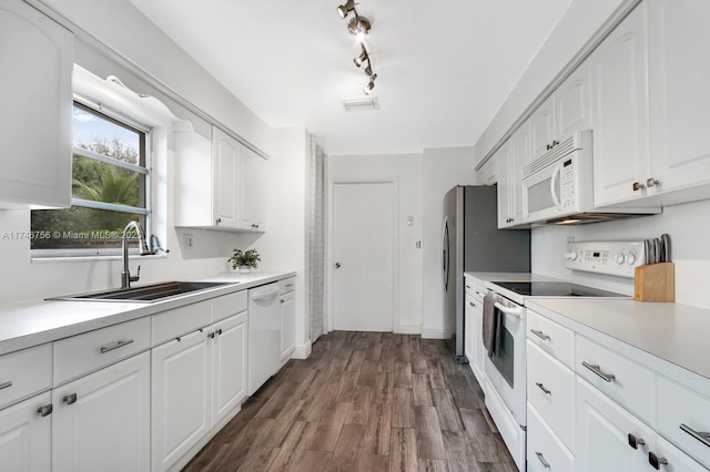 kitchen featuring a sink, white appliances, white cabinets, and light countertops