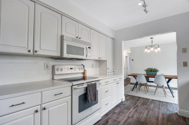 kitchen with pendant lighting, light countertops, white appliances, and white cabinetry