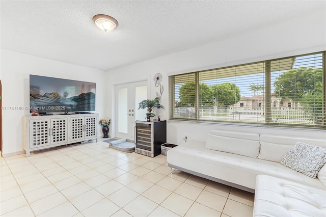 living room featuring french doors, a healthy amount of sunlight, a textured ceiling, and light tile patterned floors