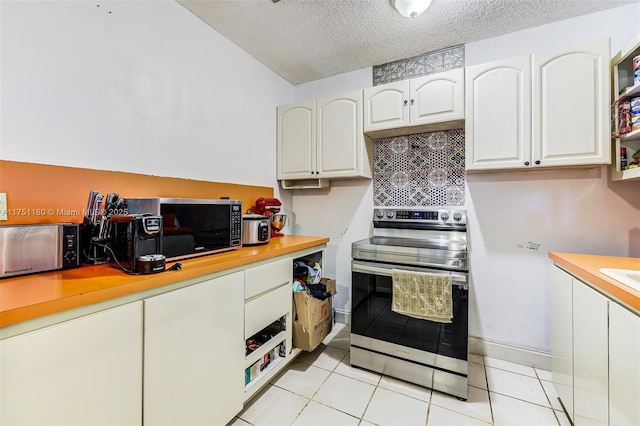 kitchen featuring a textured ceiling, light tile patterned floors, white cabinets, light countertops, and stainless steel electric range