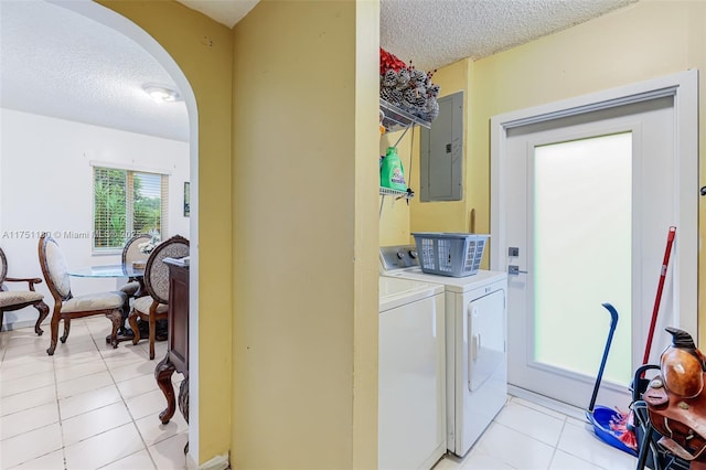 laundry room with arched walkways, a textured ceiling, washer and dryer, laundry area, and electric panel