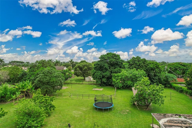 view of yard with a trampoline and fence