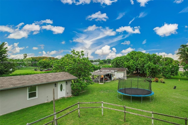 view of yard with a trampoline and an outdoor structure