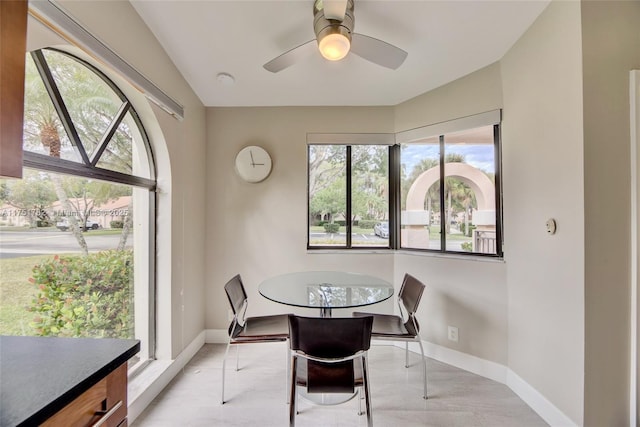 dining area featuring a ceiling fan, a wealth of natural light, and baseboards