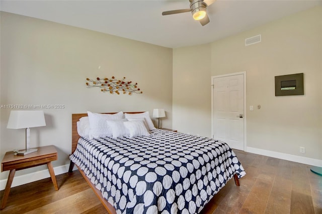 bedroom with visible vents, dark wood finished floors, and baseboards