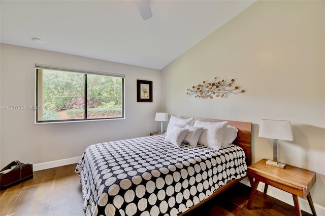 bedroom with a ceiling fan, baseboards, vaulted ceiling, and wood finished floors