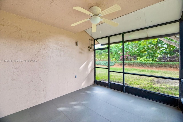 unfurnished sunroom with ceiling fan