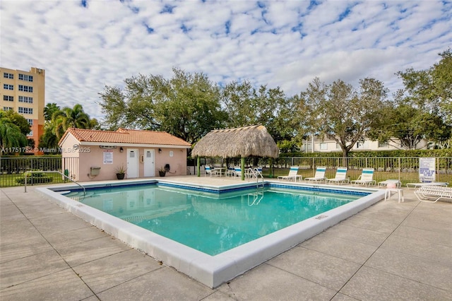 community pool with a patio and fence