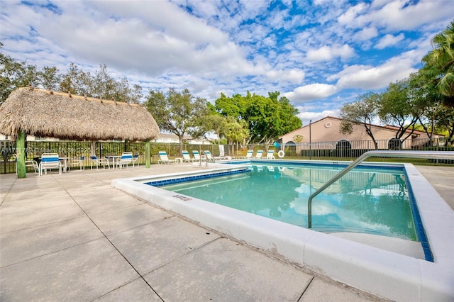 community pool with a gazebo, a patio area, and fence