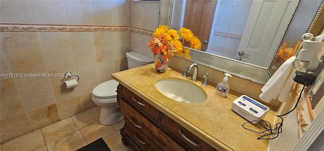 half bathroom featuring tile patterned flooring, tile walls, toilet, and vanity