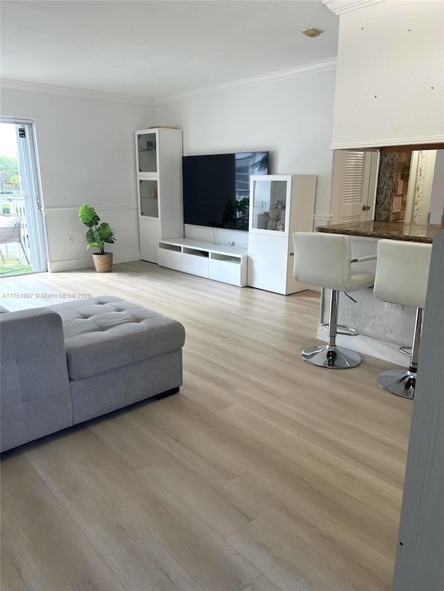 living area featuring light wood-style floors and ornamental molding