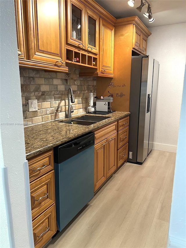 kitchen with light wood finished floors, stainless steel fridge with ice dispenser, dishwashing machine, brown cabinets, and a sink